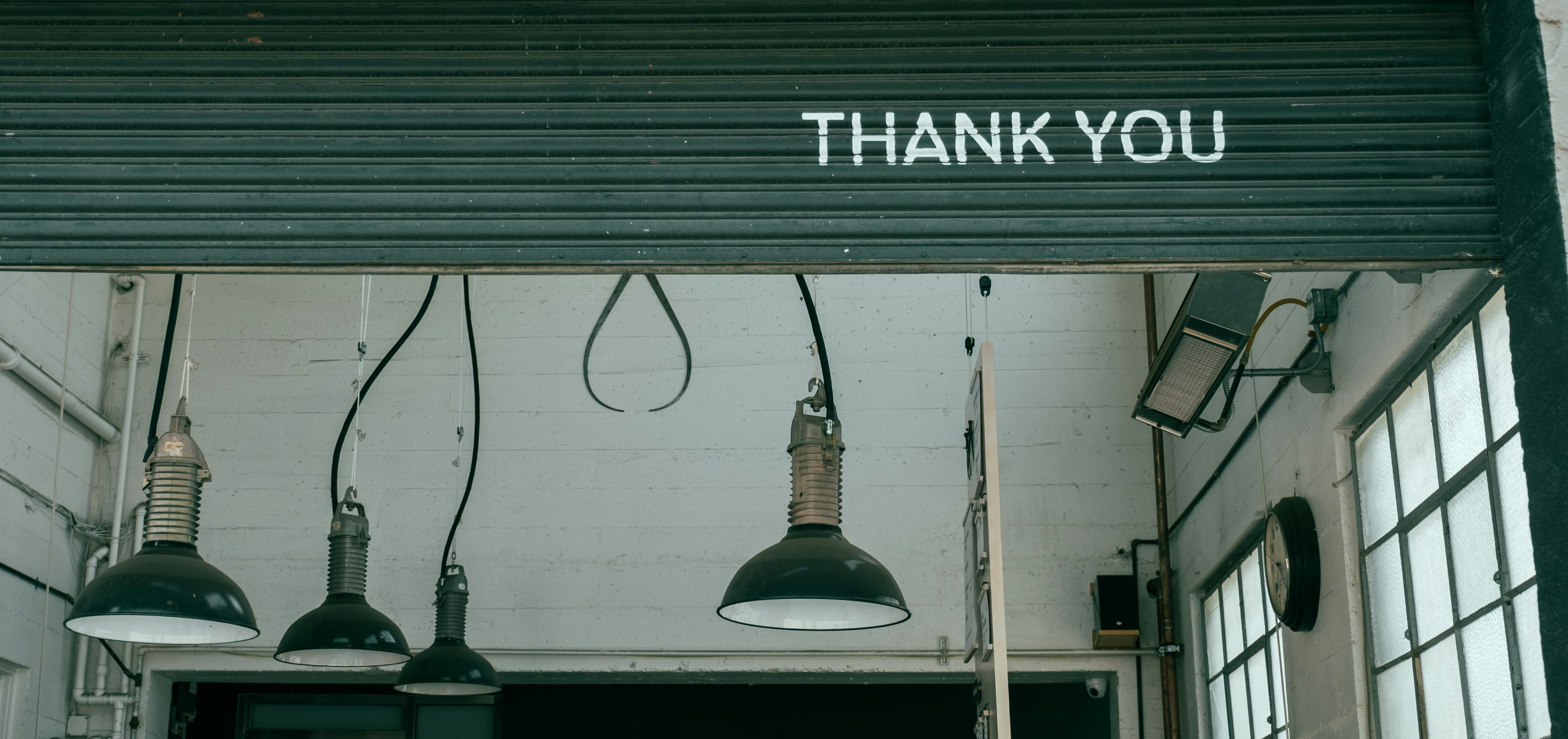 Schwarzes Rolltor mit 'Thank You' als Abschluss – Symbol für Transparenz und rechtliche Informationen im Impressum.